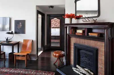 a living room with a fireplace and a chair at The High Line Hotel in New York