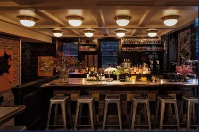 a bar with stools in a room with a counter at The High Line Hotel in New York