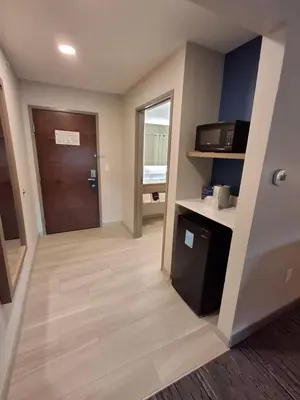 a hallway of a hotel room with a door and a microwave at Holiday Inn Express Selinsgrove by IHG in Shamokin Dam