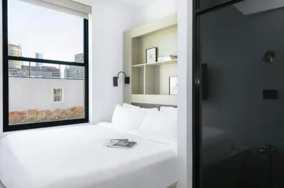 a bedroom with a white bed and a window at Walker Hotel Tribeca in New York