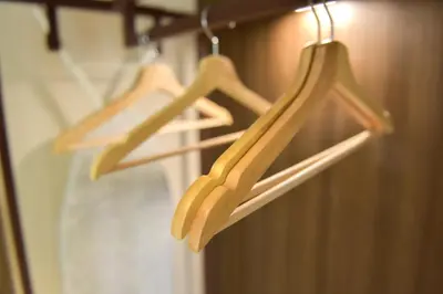 two wooden hangers are hanging on a rack at Wyndham Garden North Bergen - Secaucus in North Bergen