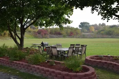 a table and chairs under a tree in a field at Relax Inn in Fisherville