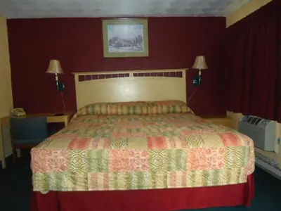 a bedroom with a bed and a red wall at Relax Inn in Fisherville
