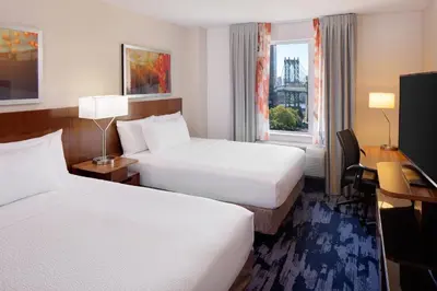 a hotel room with two beds and a desk at Fairfield Inn & Suites New York Manhattan/Downtown East in New York