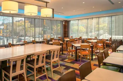a restaurant with tables and chairs and large windows at Fairfield Inn & Suites New York Manhattan/Downtown East in New York