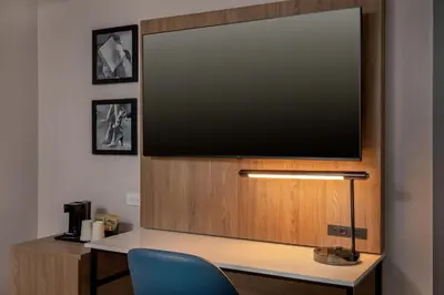 a flat screen tv on top of a desk with a blue chair at Courtyard by Marriott Times Square West in New York