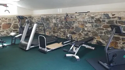 a gym with several exercise equipment in front of a stone wall at The Inn at Montchanin Village & Spa in Montchanin