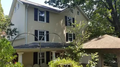a white house with black windows and a roof at The Inn at Montchanin Village & Spa in Montchanin