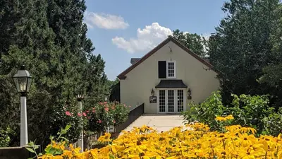 a white house with a bunch of yellow flowers at The Inn at Montchanin Village & Spa in Montchanin