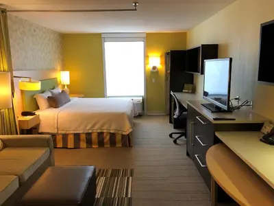 a hotel room with a bed and a desk with a television at Home2 Suites by Hilton Rahway in Rahway