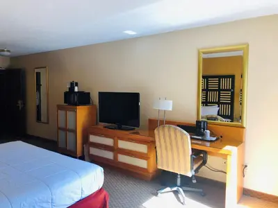 a hotel room with a bed and a desk with a television at Hotel M Mount Pocono in Mount Pocono