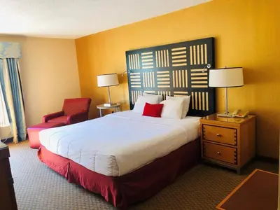 a hotel room with a large bed and a red chair at Hotel M Mount Pocono in Mount Pocono