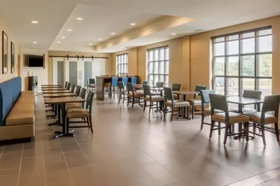 a dining room with tables and chairs and windows at Comfort Inn & Suites Gap Amish Country in Gap