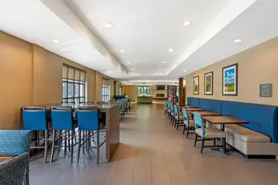 a dining room with tables and blue chairs at Comfort Inn & Suites Gap Amish Country in Gap