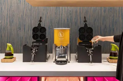 a person holding a cup in front of a coffee maker at Home2 Suites By Hilton Glen Mills Chadds Ford in Glen Mills
