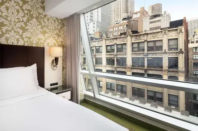 a bedroom with a bed and a large window at Best Western Premier Herald Square in New York