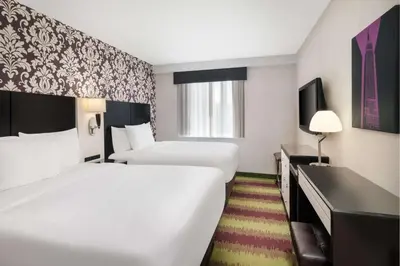 a hotel room with two beds and a desk at Best Western Premier Herald Square in New York