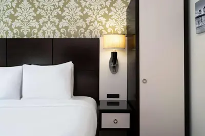 a bedroom with a bed and a lamp and a wall at Best Western Premier Herald Square in New York
