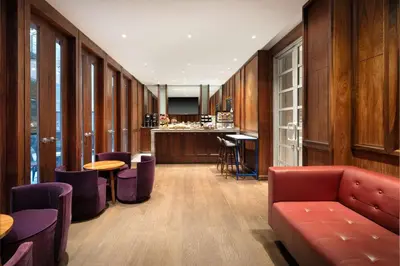 a lobby with a couch and tables and a bar at Best Western Premier Herald Square in New York