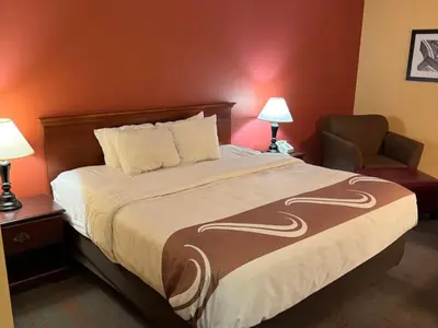 a hotel room with a bed and a chair at Appalachian Hotel in Carlisle