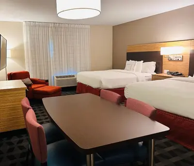 a hotel room with two beds and a table at TownePlace Suites by Marriott Clinton in Clinton