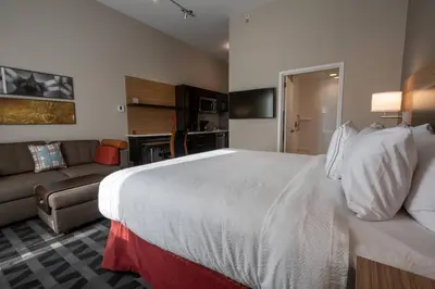 a hotel room with a large bed and a couch at TownePlace Suites by Marriott Clinton in Clinton