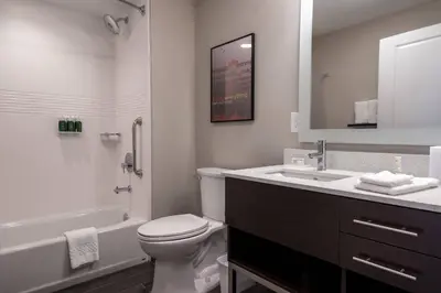 a bathroom with a toilet and a sink and a tub at TownePlace Suites by Marriott Clinton in Clinton
