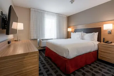 a hotel room with a bed and a flat screen tv at TownePlace Suites by Marriott Clinton in Clinton