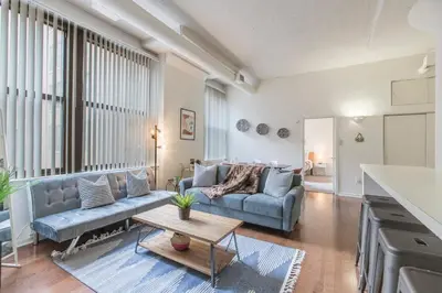 a living room with a couch and a table at Sleeps 4! 2BR, Gym, Paid Parking, Close to Major Attractions in Philadelphia