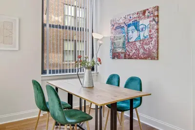 a dining room with a wooden table and green chairs at Sleeps 4! 2BR, Gym, Paid Parking, Close to Major Attractions in Philadelphia
