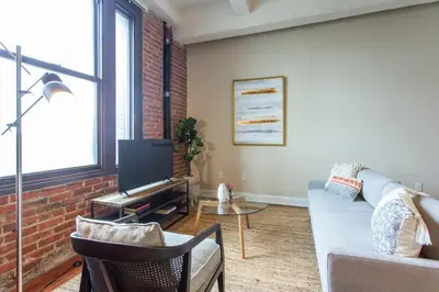 a living room with a couch and a tv at Sleeps 4! 2BR, Gym, Paid Parking, Close to Major Attractions in Philadelphia