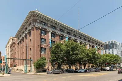 a large brick building with cars parked in front of it at Sleeps 4! 2BR, Gym, Paid Parking, Close to Major Attractions in Philadelphia