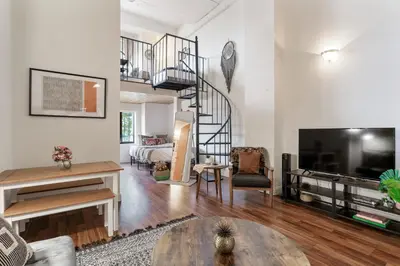 a living room with a spiral staircase in a room at Sleeps 4! 2BR, Gym, Paid Parking, Close to Major Attractions in Philadelphia