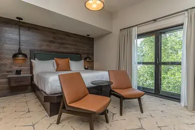a bedroom with a bed with two chairs and a table at Ghost Light Inn in New Hope