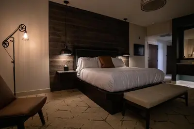 a bedroom with a large bed and a chair at Ghost Light Inn in New Hope