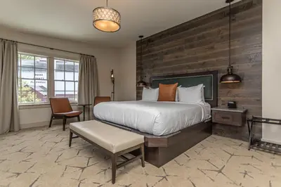 a bedroom with a large bed and a wooden wall at Ghost Light Inn in New Hope