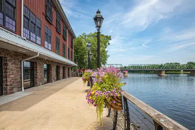 a building with flowers on a fence next to a river at Ghost Light Inn in New Hope