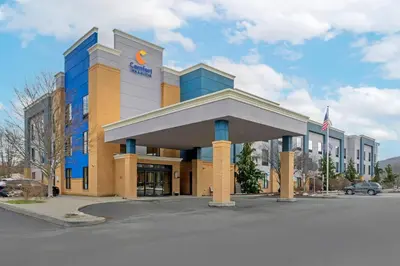 a large building with an entrance in a parking lot at Comfort Inn & Suites Sayre in Sayre
