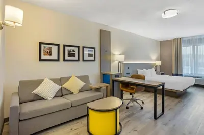 a hotel room with a couch and a bed and a desk at Comfort Inn & Suites Sayre in Sayre