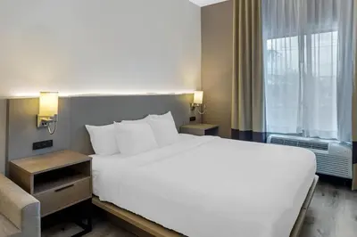 a bedroom with a large white bed and a window at Comfort Inn & Suites Sayre in Sayre