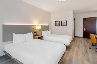 a hotel room with two beds and a desk at Comfort Inn & Suites Sayre in Sayre