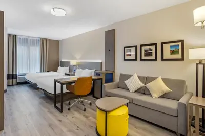a hotel room with a bed and a couch at Comfort Inn & Suites Sayre in Sayre