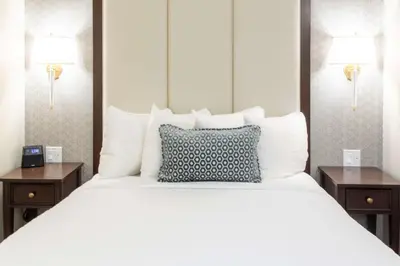 a large white bed with two night stands and two lamps at Independence Park Hotel, BW Premier Collection in Philadelphia