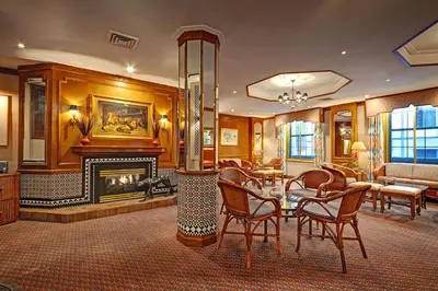 a living room with a fireplace and a table and chairs at Casablanca Hotel by Library Hotel Collection in New York