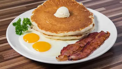 a plate of breakfast food with pancakes and bacon at Radisson Lackawanna Station Hotel Scranton in Scranton