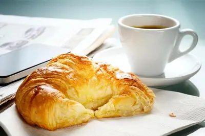 a pastry sitting on a napkin next to a cup of coffee at Radisson Lackawanna Station Hotel Scranton in Scranton