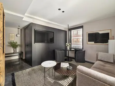 a living room with a couch and a tv at Hotel AKA NoMad in New York