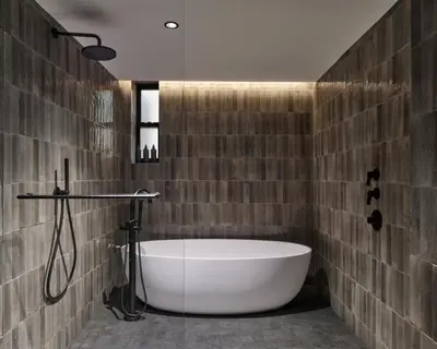 a bath tub in a bathroom with a tile wall at Hotel AKA NoMad in New York