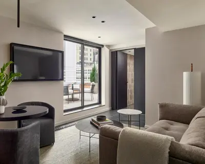 a living room with a couch and a tv at Hotel AKA NoMad in New York