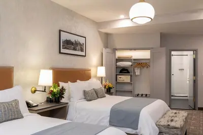 a hotel room with two beds and a desk at Broadway Plaza Hotel in New York